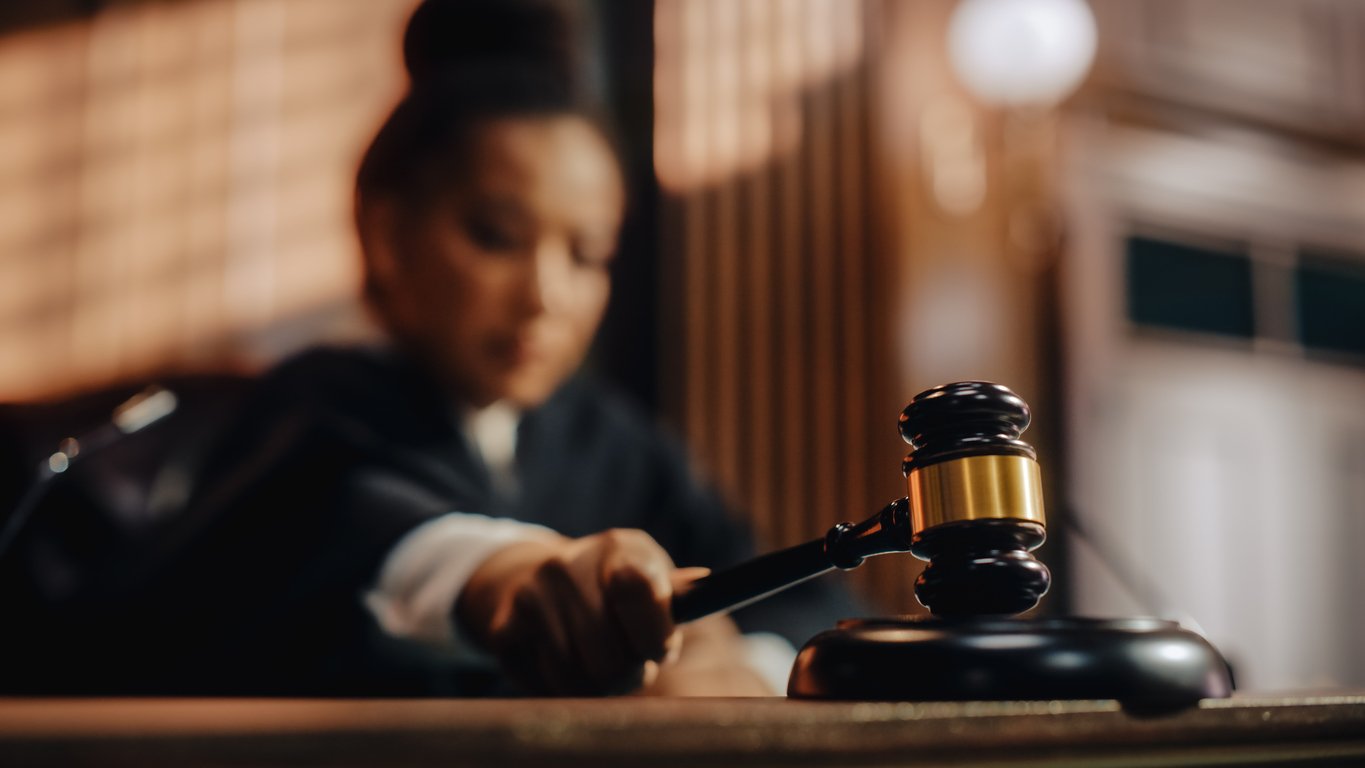 Court of Law Trial in Session: Honorable Female Judge Pronouncing Sentence, striking Gavel. Focus on Mallet, Hammer. Cinematic Shot of Dramatic Not Guilty Verdict. Close-up Shot. Credit: iStock