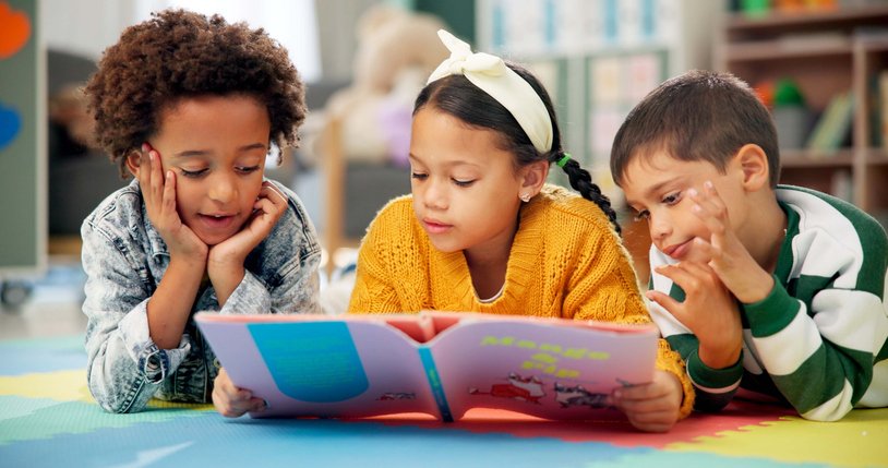 Children, kindergarten and reading book in classroom, childhood development and growth for vocabulary in school. Listening, knowledge and information with storybook, learning and fantasy for friends iStock